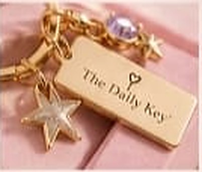 Close-up of a gold tag and star charm on blush fabric