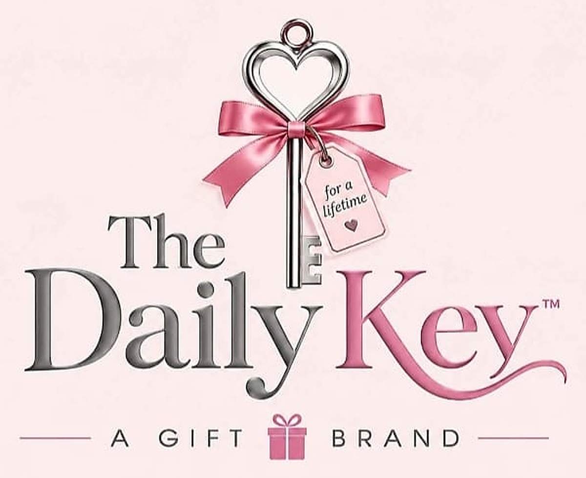 The Daily Key logo: a silver heart key with a pink bow and tag